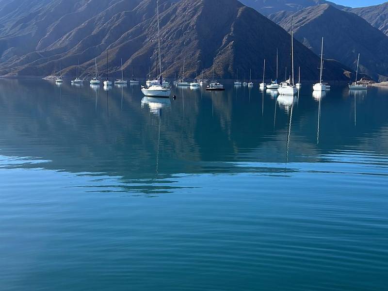 Veleros fondeados en el embalse, con la montaña detrás